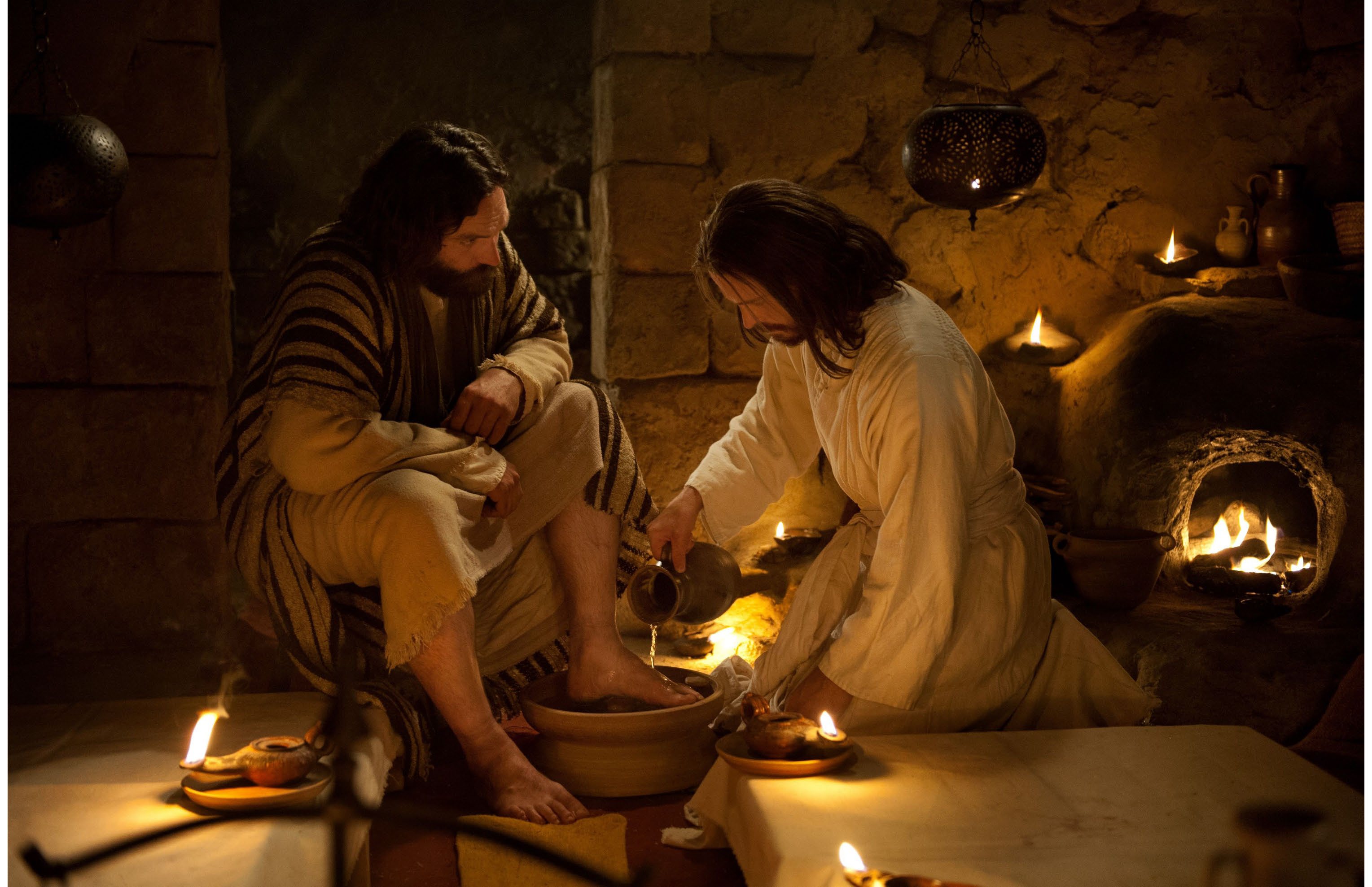 Jesus washing the feet of His disciples by candlelight